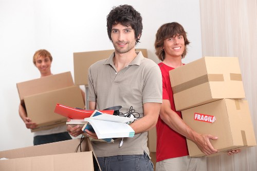 Professional team handling piano removals in Kentishtown with protective wrapping